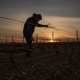 Morgann, vigneron du Champagne William Saintot dans ses vignes lors de la taille avec un coucher de soleil
